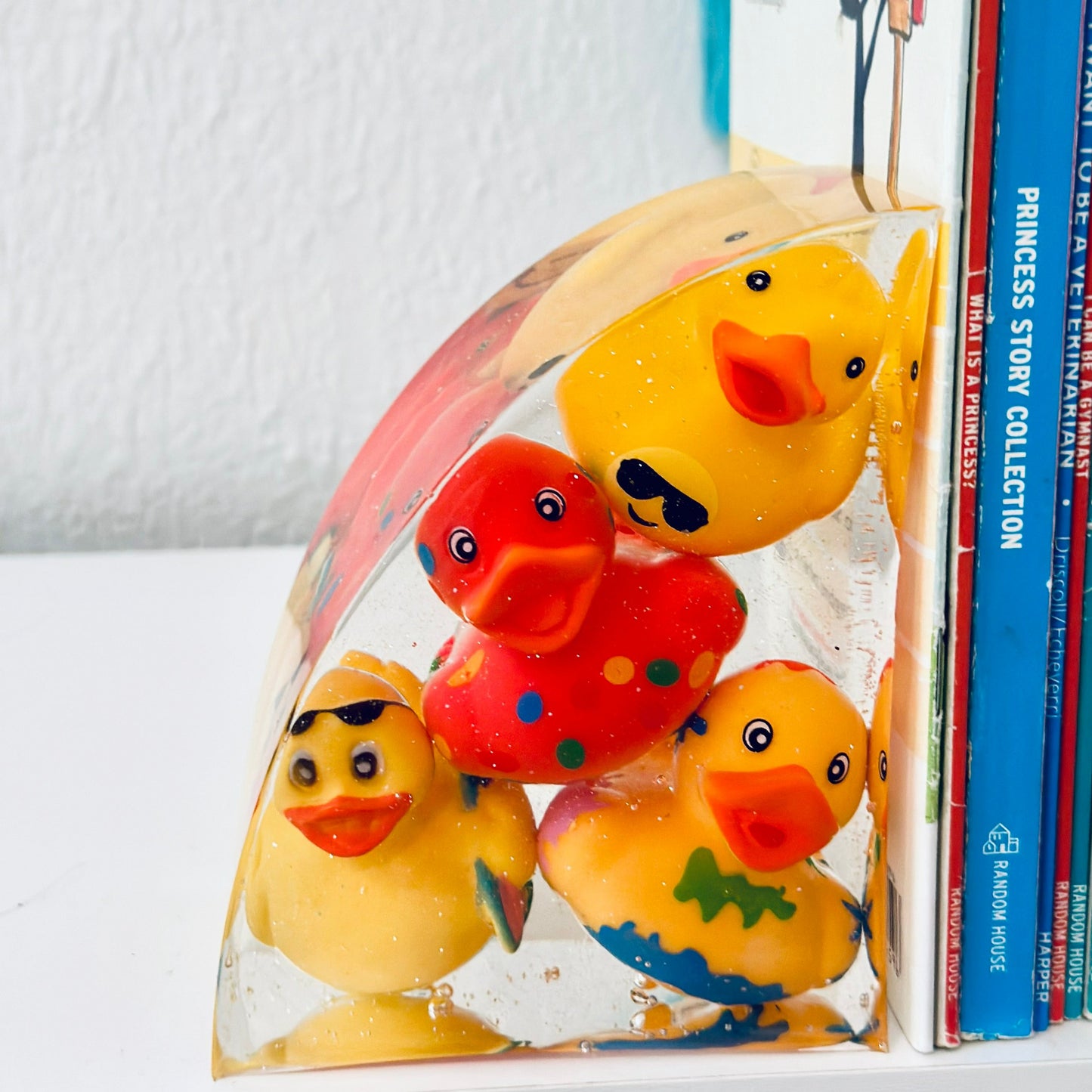 Nursery bookshelf with the ducky bookends holding up children's books.